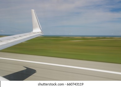Slow shutter view from inside of plane taking off showing wing tip