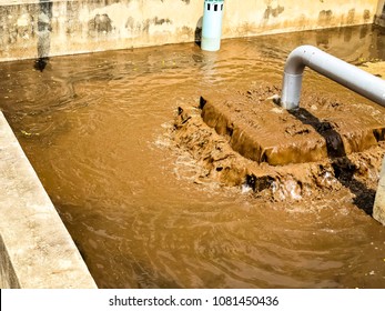 Sludge Treatment In Wastewater Management System, Flowing Brown Smelly Liquid And Drying, Made It For Fertilization Can Use In Agriculture Field. Cement And Concrete Well Background.