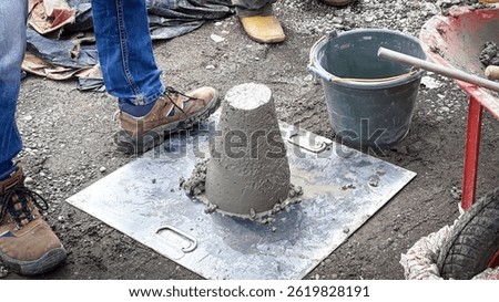 Slump test to measure concrete workability—height difference indicates consistency and flowability for quality control on-site.