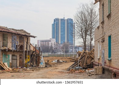 Slums on the background of a modern high-rise building. Demolition of old dilapidated buildings and clearing for the construction of modern buildings in Minsk, Belarus 07.04.2019.