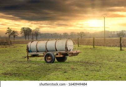 Slurry Tankers In A Meadow At Sunset