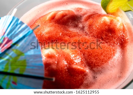 Slushy Red Drink with lime and umbrella.