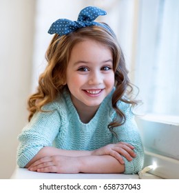 Sly Girl With Accessories In Her Hair Blue Blouse And Jeans Smiling. Fashion