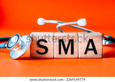 SMA spinal muscular atrophy, Medical stethoscope and text on wooden blocks, Orange background, medical concept, disease entity