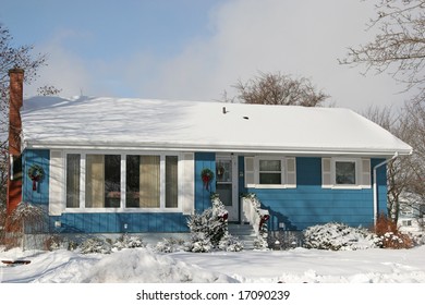 A Small 1970's Or Late 60's Bungalow Decorated For Christmas And Covered In Snow.