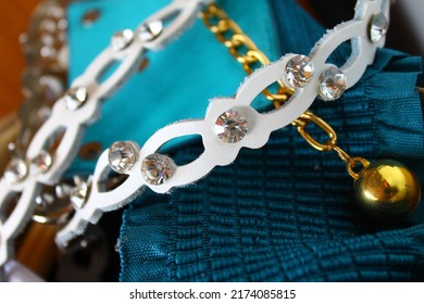 a small abstraction of women's accessories and jewelry chains, straps and pendants, leather and rhinestones. against the background of golubots and blue openwork fabric.