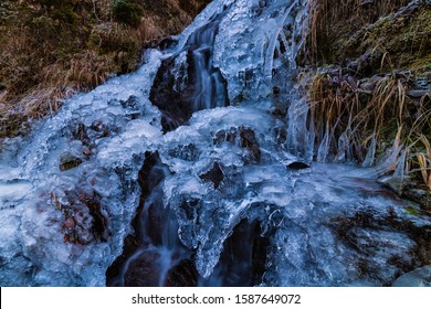 A small active waterfall. Clean mountain stream, snowy winter landscape, wildlife background