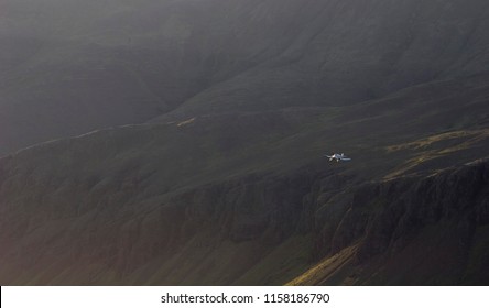 Small Aircraft Flying By A Mountain Range 
