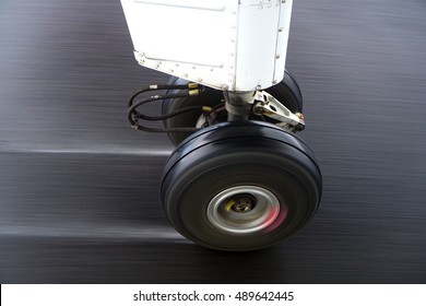 A Small Aircraft's Landing Gear With The Wheels Spinning As The Plane Touches Down