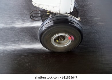 A Small Aircraft's Landing Gear With The Wheels Spinning As The Plane Touches Down