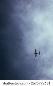 Small airplane flying in dramatic cloudy sky, minimalistic travel and aviation background