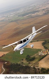 Small Airplane Flying Over Farm