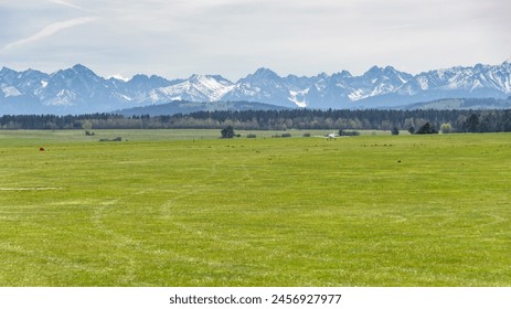 Small airplane on the sport grass airfield in Nowy Targ. Tatra mountain in the background. - Powered by Shutterstock