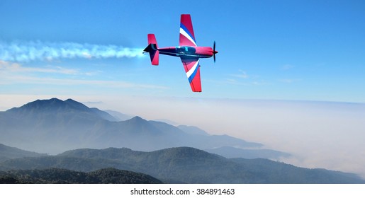 Small Airplane In The Sky Above The Mountains