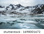 A small alpine lake thawing in spring below Montana Peak in the Alaskan wilderness of the Talkeetna Mountains.