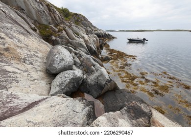 Small Aluminium Boat Anchored At Rocky Coast