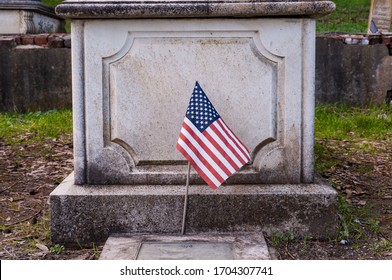 Small American Flag Placed In Front Of Marble Grave Casket Soldier Killed In Battle War.