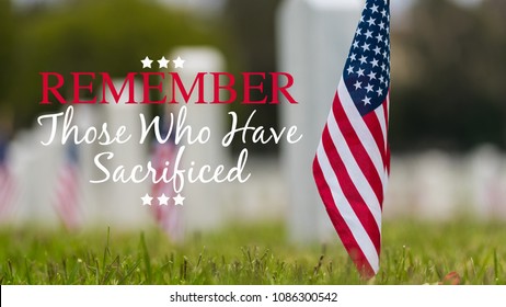 Small American flags and headstones at National cemetary- Memorial Day display - with copy
