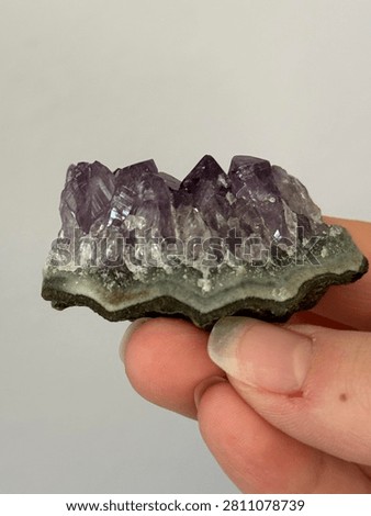 small amethyst cluster side view closeup hand holding semiprecious February birthstone crystal mineral energy natural nature