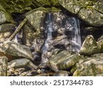 small amount of water  flowing over trap falls in willard brook state forestt in ashby masschusetts