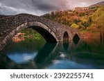 Small ancient stone arch bridge  in Rijeka Crnojevica on a rainy day, Montenegro