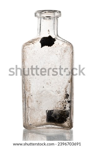 A small Antique vintage glass bottle, on white background. recovered from an archaelogical dig. Old bottle with calcium deposits and pollution