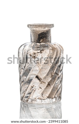 A small Antique vintage glass bottle, on white background. recovered from an archaelogical dig. Old bottle with calcium deposits.