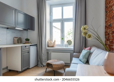 Small Apartment In Industrial Loft With Window, Bricky Wall And Kitchen. Living Room With Sofa, Pillows And Coffee Table. Hotel.