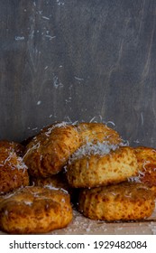 A Small Aperture Photograph Depicting A Pile Of Cheese Scones Being Dusted With Grated Parmesan Cheese Against A Grey Background. 