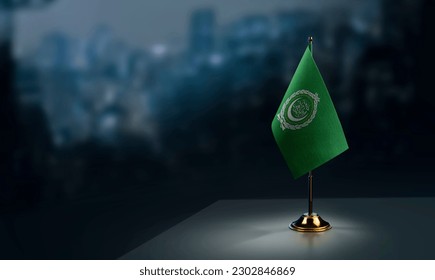 A small Arab League flag on an abstract blurry background.