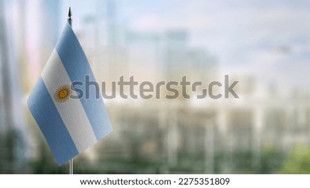A small Argentina flag on an abstract blurry background.