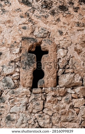 Small arrow-slit window in a stone wall