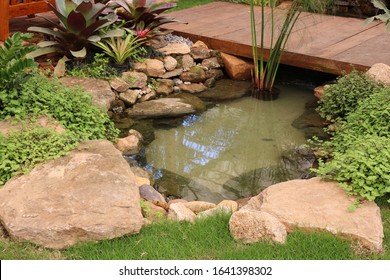 Small Artificial Lake With A Bridge In A Garden