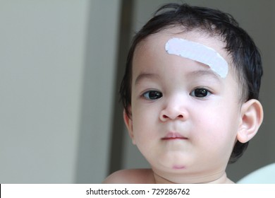 A Small Asian Toddler Boy With A Bruised And Bandage On Face.1 Year Old Boy Has Accident,Accidental Injuries Are A Major Health Problem In Children Over One Year Of Age. Common Danger At Home.