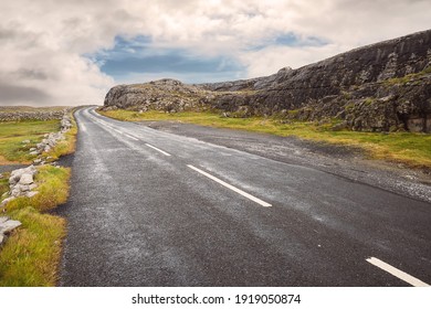 Small Asphalt Road On West Coast Of Ireland, Part Of Wild Atlantic Way Route. Beautiful Cloudy Sky In The Background, Rough Stone Terrain. Burren Area, Irealnd