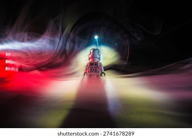 Small astronaut facing distant light in smoky abstract scene