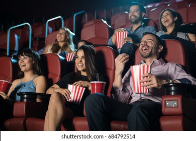 Small Audience Of People Laughing At The Movie Theater While Watching A Comedy And Having A Good Time