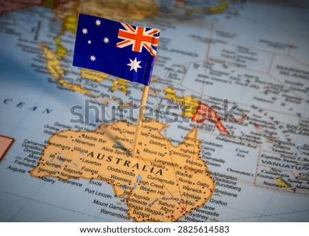 Small Australian flag positioned on map of Australia symbolizing travel planning tourism and international connections in southern hemisphere.