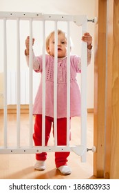 Small Baby Approaching Safety Gate Of  Stairs