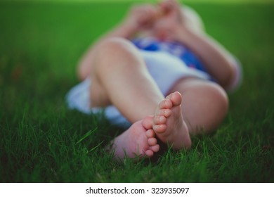 Small Baby Feet On The Green Grass