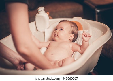 Small Baby First Bathing On Mothers Hands