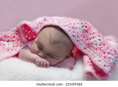 Small Baby Sleeping With Hand Made Crochet Blanket Laying Across Her Head