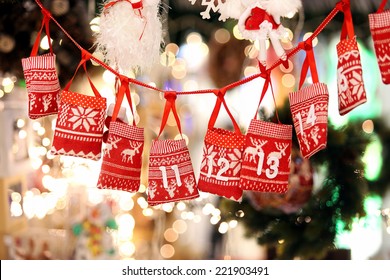 Small bags as Advent calendar with Sweets surprises hanging on a ribbon against lights blurred background - Powered by Shutterstock