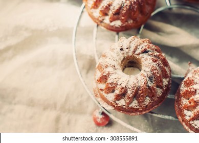 Small Baked Cakes Dusted with Icing Sugar on Linen Napkin. Toned image - Powered by Shutterstock