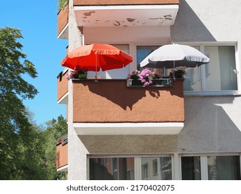 Small Balcony with Red Parasol and White Umbrella Sunshade Beach Umbrella Home Blue Sky in Summer in Berlin Kreuzberg Germany Europe