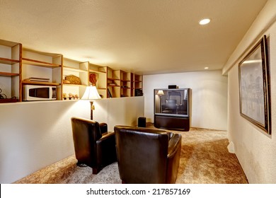 Small Basement Room Interior. Two Leather Chairs And Tv.