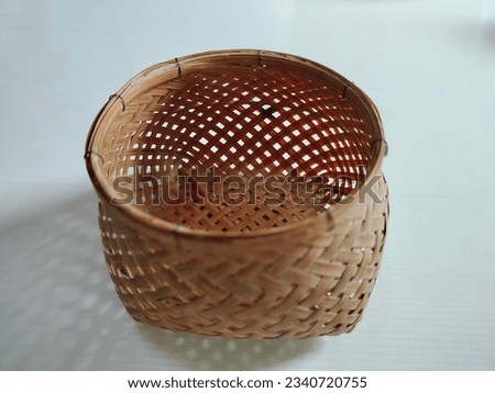 A small basket made of rattan for storing miscellaneous items.
