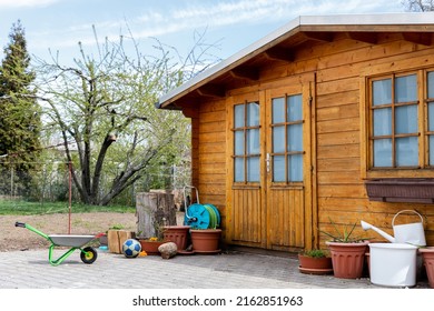 Small beautiful wooden house shed or storage hut for garden tools equipment and bicycles at backyard at beautiful american or european countryside backyard. Cozy rural yard stuff warehouse.