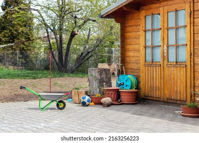 Small beautiful wooden house shed or storage hut for garden tools equipment and bicycles at backyard at beautiful american or european countryside backyard. Cozy rural yard stuff warehouse