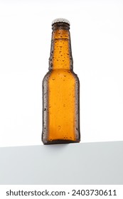 small Beer bottle with water drops isolated on white, white cap, seen from below